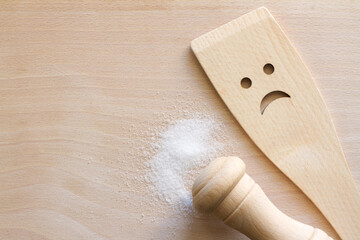 Salt with wooden spoon on cutting board, unhealthy food additives concept