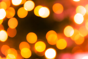 Blurred lights on the Christmas tree. Festive abstract dark background with yellow and red spots. Copy space