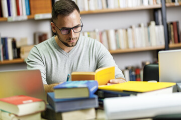 Male student studying in campus library .