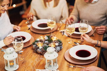 Friends celebrating christmas party holding wine