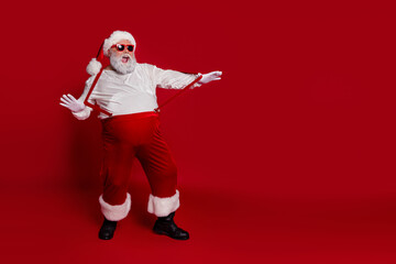 Fototapeta na wymiar Photo of crazy positive retired man dance disco pull suspenders wear santa hat costume isolated red color background