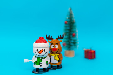 Toys Snowman, deer, gift boxes on blue background with copy space.Selective focus.