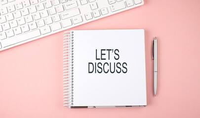 Pink office desk with keyboard and notebook , text LET'S DISCUSS