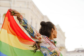 Smiling african woman holding rainbow lgbt flag