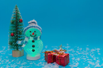 Glowing snowman, presents and Christmas tree with copy space.new year celebration.
