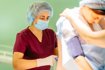 Pregnant woman has a peridural anesthesia by child birth. Epidural anesthesia injections. Prepare for surgery. Medical background. - obrazy, fototapety, plakaty
