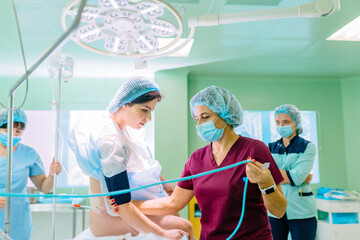 Nurse operating room composition help female patient the anesthesiologist works in the operating...