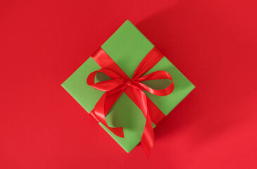 gift box green on red background with red bow with place for text