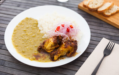traditional Peruvian dish. chicken wings with pea puree, rice and pickled onions