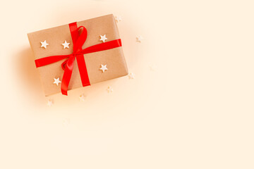 Christmas gift box with red bow on beige background. Holiday concept, New year presents.