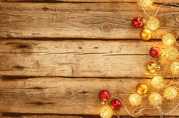 christmas lights and balls on a wooden background with copy space