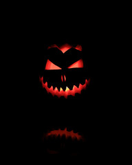 Halloween Head Jack Pumpkin with Scary Smile and Burning Candle Inside for Party Night on Black Background