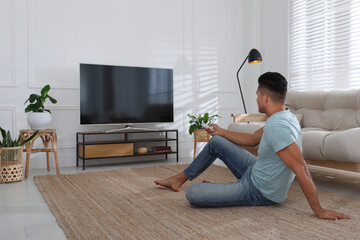 Man watching television at home. Living room interior with TV on stand