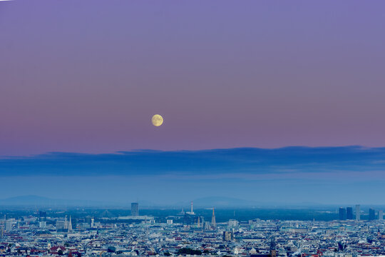 HDR image of Vienna with the moon almost full over the city