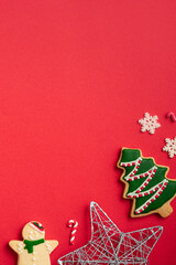 Fototapeta na wymiar Decorated Christmas gingerbread cookies with decorations on red table background.