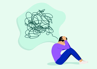 An unhappy man suffering from a mental health illness sitting on the floor crying. Stressed boy has symptoms of depression, anxiety, ADHD or sad feelings. In a crisis, exhausted with messy thoughts