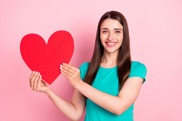 Fototapeta na wymiar Photo of young excited woman happy positive smile romantic love hold paper heart isolated over pink color background