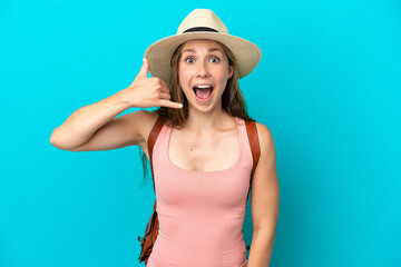 Naklejka premium Young caucasian woman in summer holidays isolated on blue background making phone gesture. Call me back sign