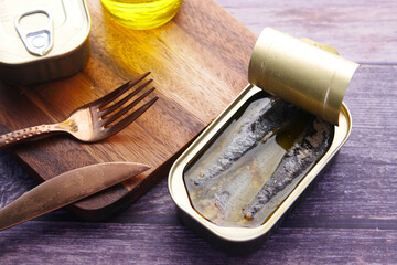 open tin of sardines on white tiles background.