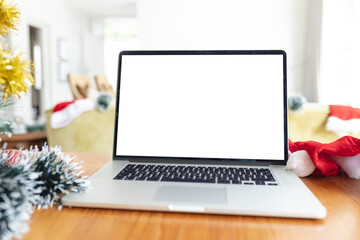 Laptop with copy space on screen lying on table with christmas decorations