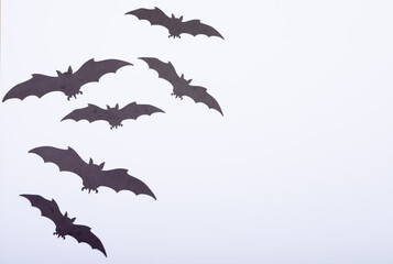 Composition of multiple halloween black bats flying with copy space on white background - Powered by Adobe