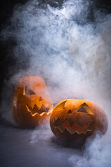Composition of halloween carved pumpkins and cloud of smoke with copy space on black background
