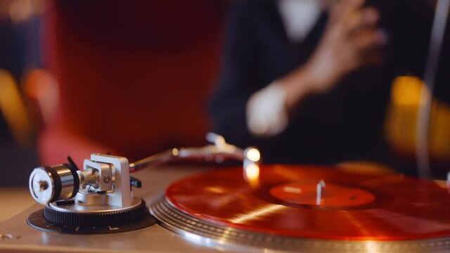 Woman Listening To Red Vinyl Record Playing On Record Player