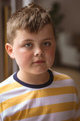 Portrait of caucasian boy standing in the living room at home