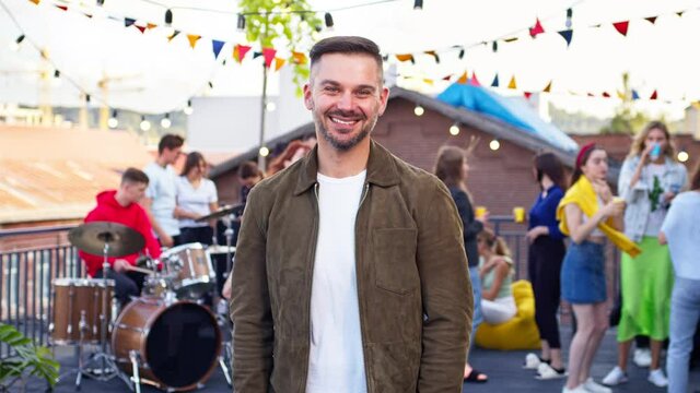 Portrait Of Young Handsome Man Turning Head To Camera At Rooftop Party. Attractive Male Looking And Smiling To Camera. Concert, Roof Party, Fectival Concept