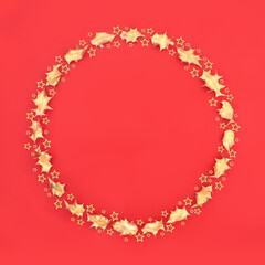 Christmas gold star and holly leaf minimal wreath on red background. Festive symbol for the holiday season. Flat lay, top view, copy space.