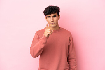 Young Argentinian man isolated on pink background frustrated and pointing to the front