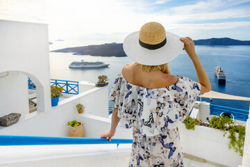 woman in Santorini looking at cruise ships in the aegean sea. Greek islands