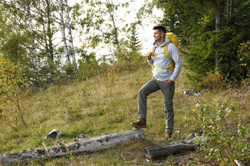 Man with yellow backpack outdoors, space for text. Tourism equipment