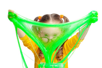 Funny cute little girl stretching green slime with her hands and looking through it on white...