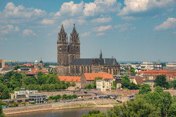 Obraz premium Aerial bird view over Magdeburg historical downtown, Elbe river, city park and the ancient medieval cathedral in Spring colors at blue cloudy sky and sunny day, Magdeburg, Germany.