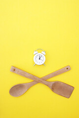 A set of bamboo dishes and a white vintage clock on a bright yellow background.