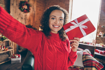 Fototapeta premium Self-portrait of attractive cheerful girl holding in hands giftbox festal time tradition occasion day at decorated home indoors