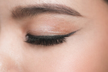 close-up portrait of young beautiful woman's closed, eye zone make up with black arrow