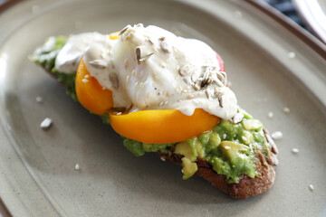 Bruschetta with guacamole, poached egg, cashew nuts close-up.