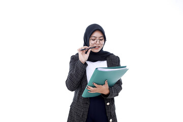 Portrait of an asian businesswoman thinking while biting a pen writing in a folder isolated on white background looking at camera