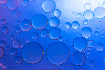 Water in oil in abstract style on blue background. blue liquid splash. Golden yellow bubble oil...