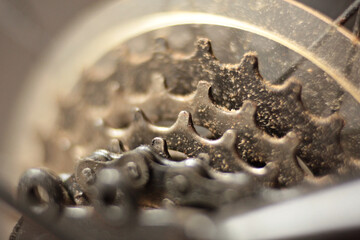 Cycling macro. Close up rear wheel gears and chain with dirt and grit. Shallow depth of field. 