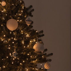 Christmas tree decorated with glowing garland lights, baubles