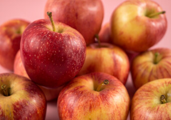 Fototapeta na wymiar Ein Haufen frischer Äpfel auf rosanen Hintergrund