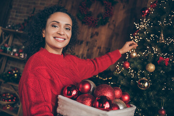 Photo of sweet cheerful young lady dressed red pullover decorating christmas tree smiling indoors room home house