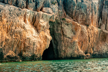 Entrance to a sea cave on a rocky island in the mediterranean sea