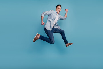 Fototapeta na wymiar Full size profile side photo of young man have fun jump up go walk run hurry isolated over blue color background
