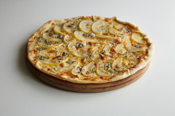 Pizza with cheese and pear fruit on cutting board