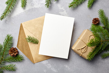 Christmas greeting card mockup with envelope, pine cones and fir tree branches