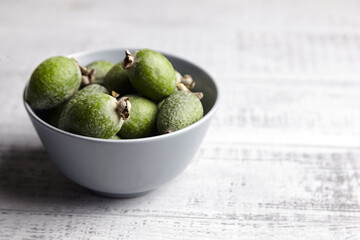 Feijoa fruits or pineapple guava in bowl on wooden table